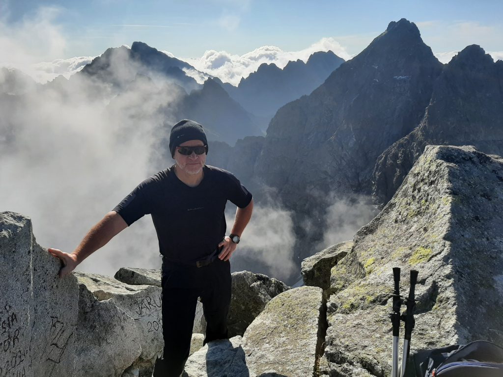 Zdjęcie przedstawiające Dariusza Marciniaka na tle panoramy Tatr Wysokich