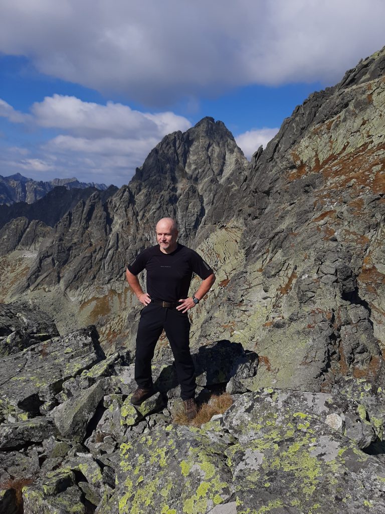 Zdjęcie przedstawiające rozmówcę, Dariusza Marciniaka, autora strony dagomar.eu, w trakcie fotografowania panoramy Tatr Wysokich. 